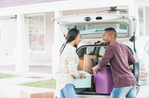 Un couple qui range des affaires dans le coffre d'une voiture