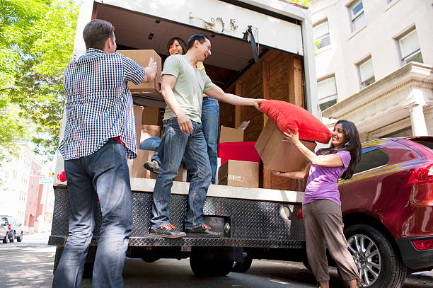 Groupe de personnes qui rangent des cartons dans un camion de déménagement