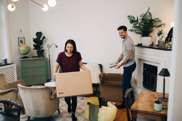 Un couple qui fait ses cartons de déménagement dans le salon de leur appartement